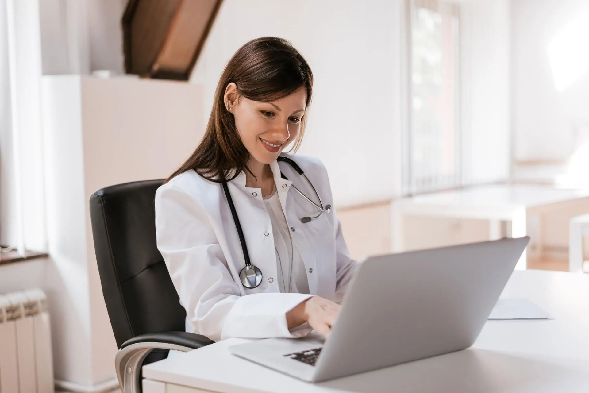 Médica do trabalho usando laptop