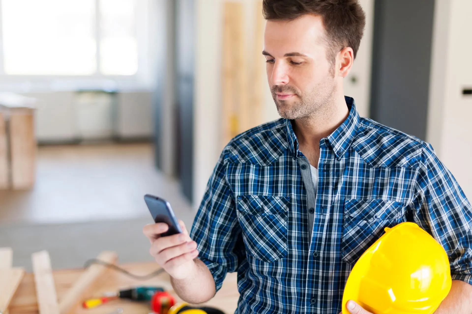 Trabalhador da construção civil com celular