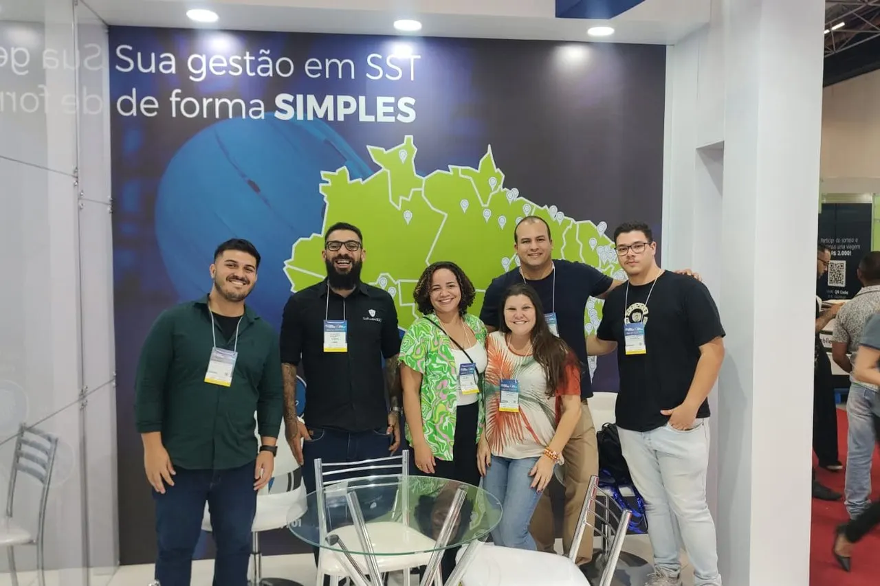 Equipe SGG reunida no estande com o painel "Sua gestão em SST de forma simples"