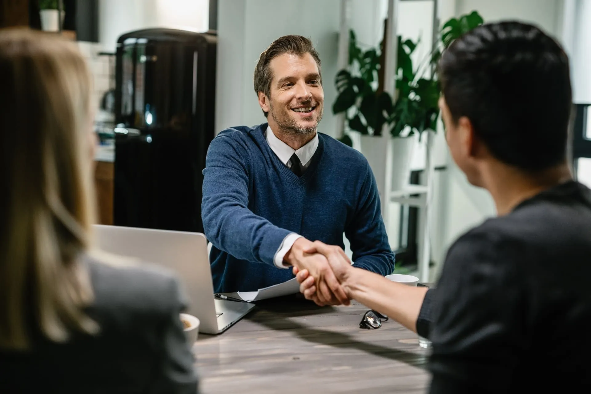 Consultor cumprimentando clientes em reunião